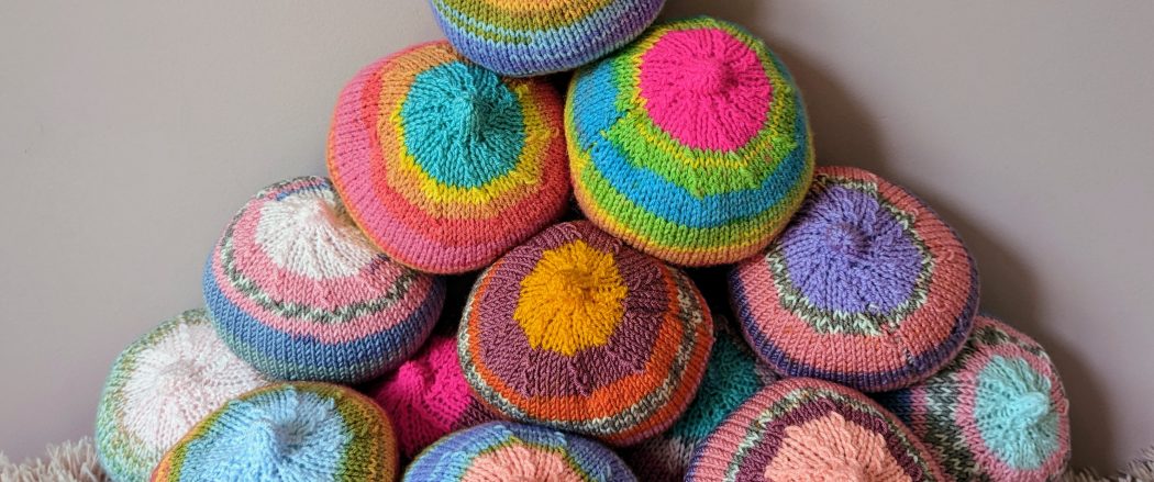 A picture of knitted breasts in rainbow colours.